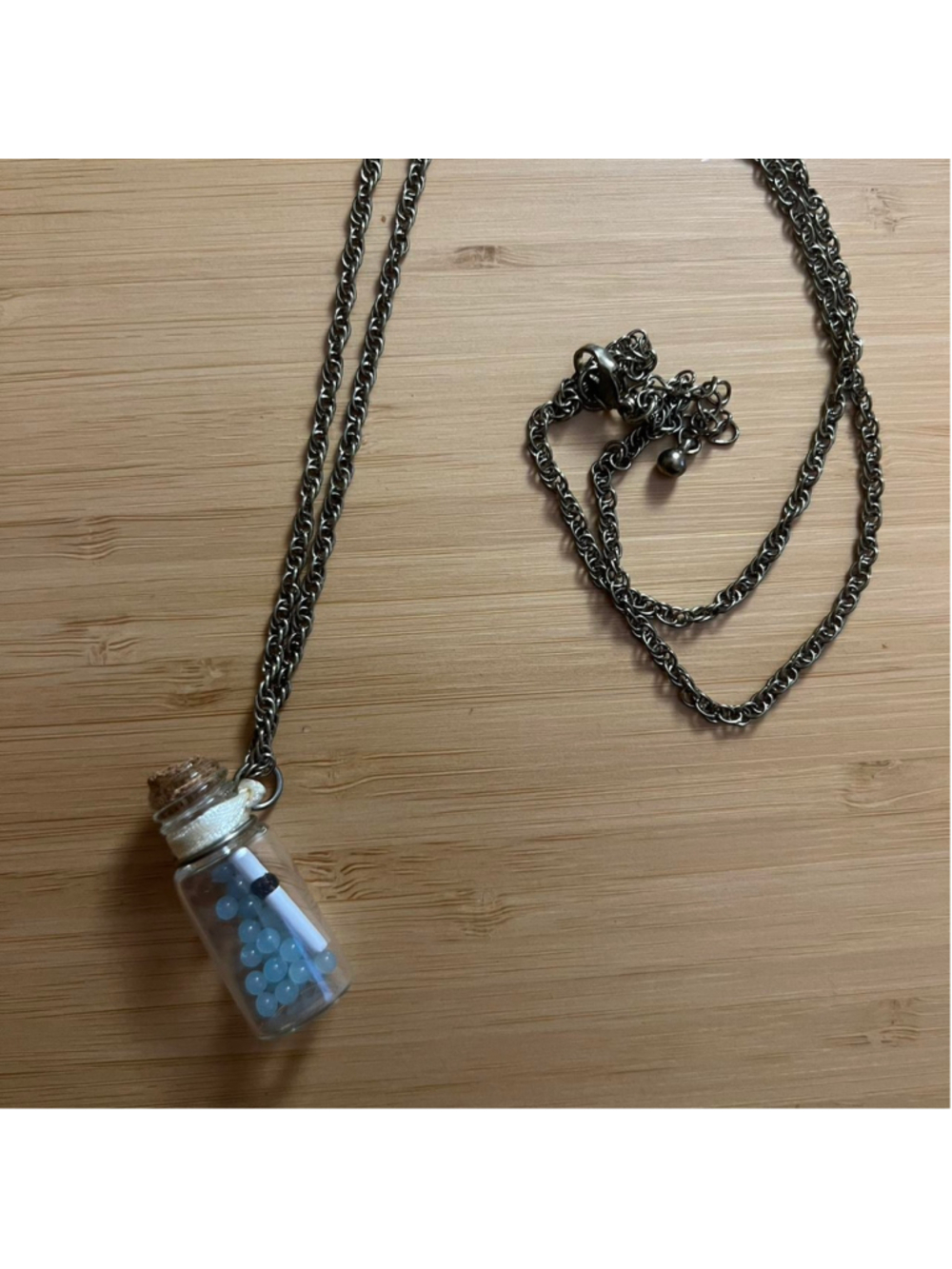 Handmade necklace with a message in a bottle charm containing actual cork, blue